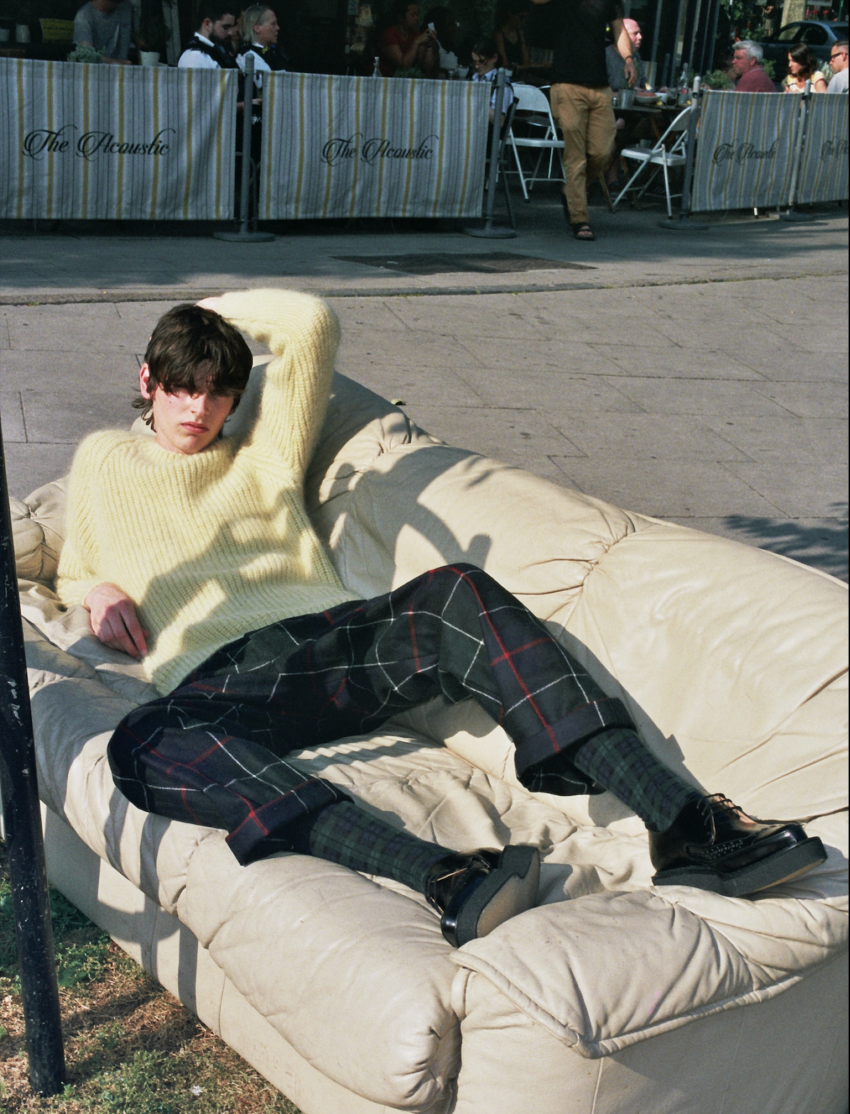 Alistair Waterfield lounging on a discarded sofa wearing black Diano Creepers